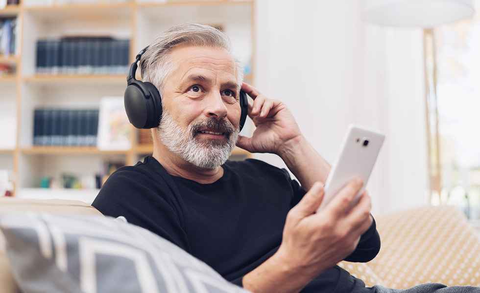 Älterer Mann mit Kopfhörer und Handy